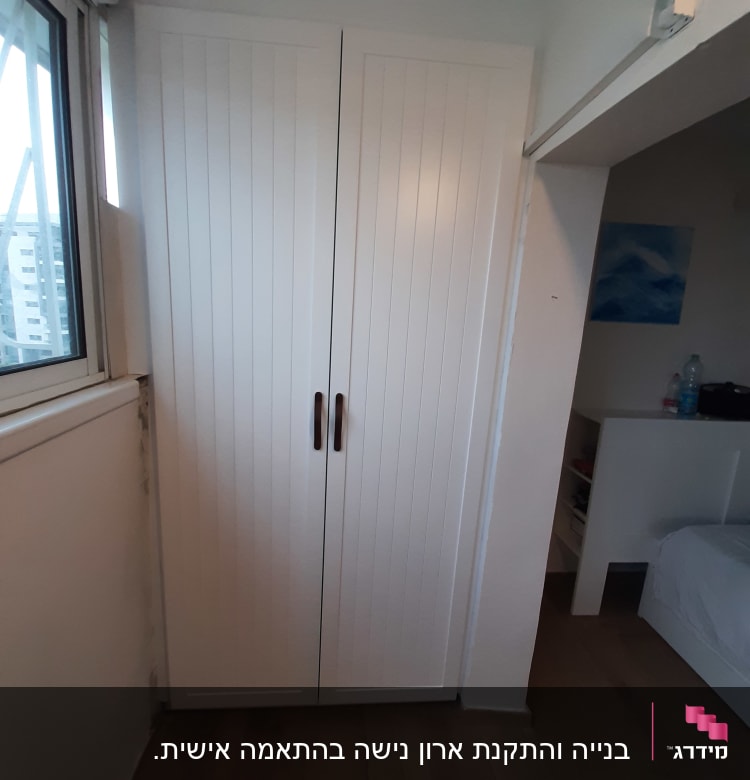 ארון עץ לבן עם ידיות מתכת כהות